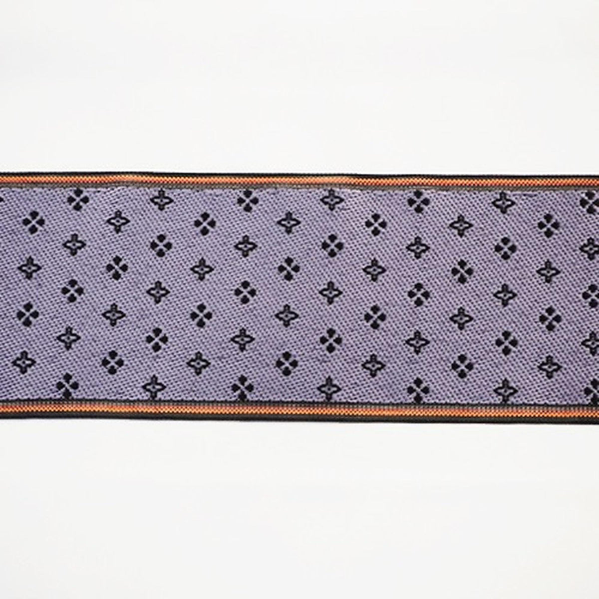 a close-up view of a fabric with a repeating pattern of small black dots or circles on a purple background.