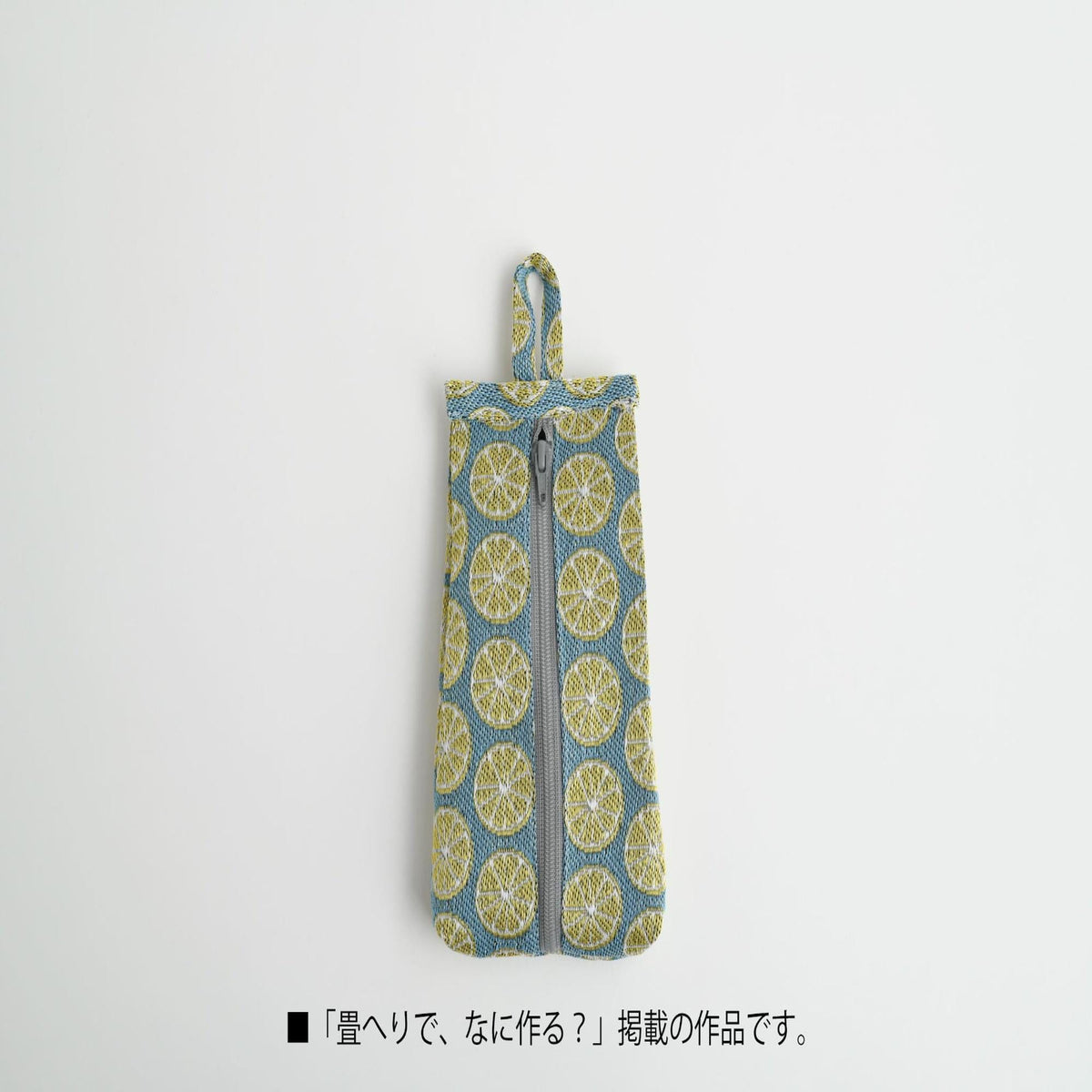 A small, colorful zippered pouch with a pattern of yellow and blue circles on a white background.