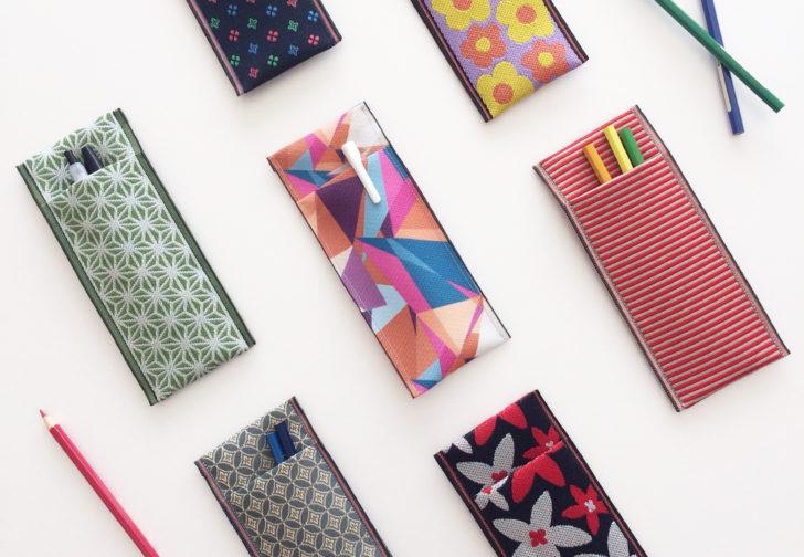 a variety of colorful pencil cases and holders, each with unique patterns and designs.
