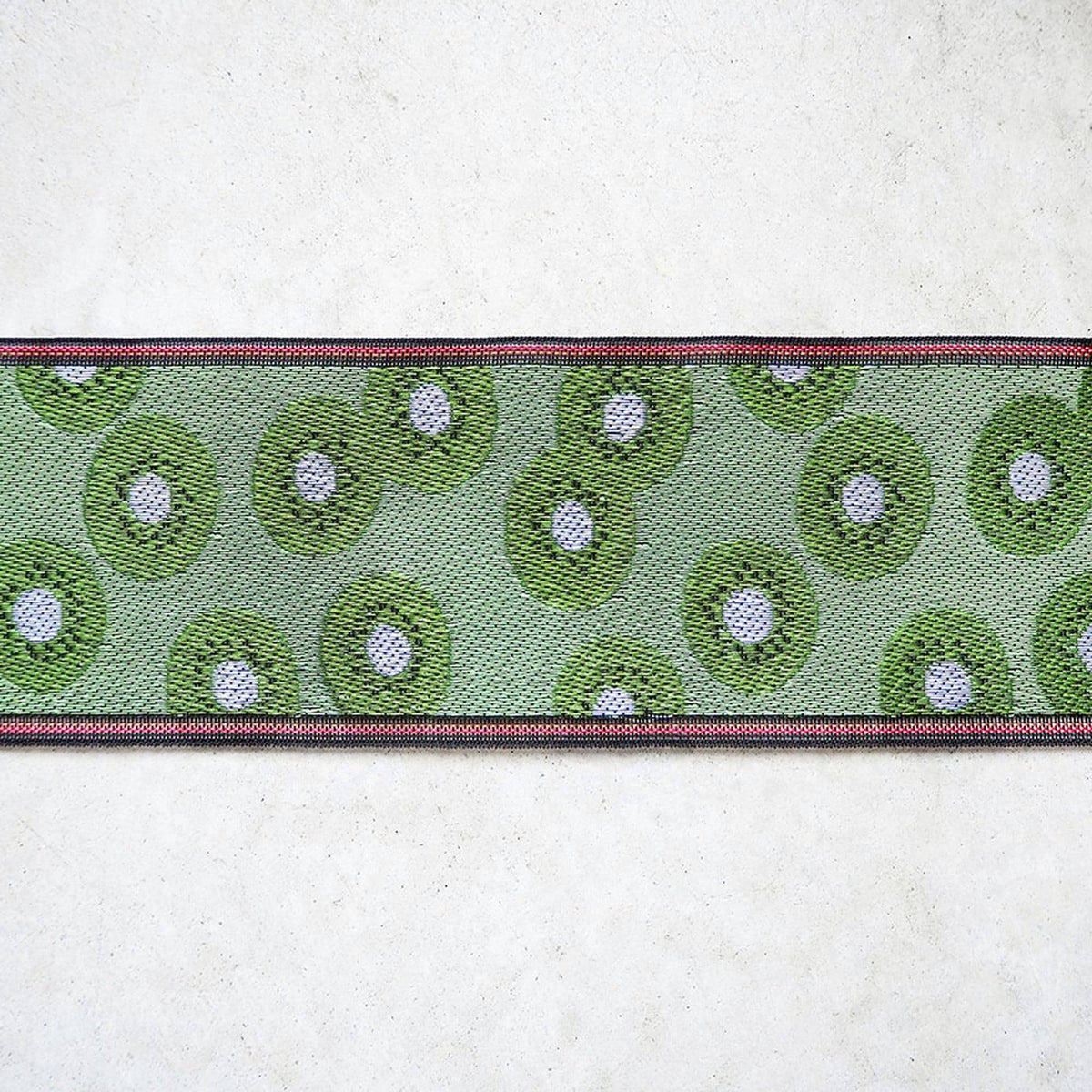 a green and white patterned fabric with a red border, arranged in a horizontal row on a white background.