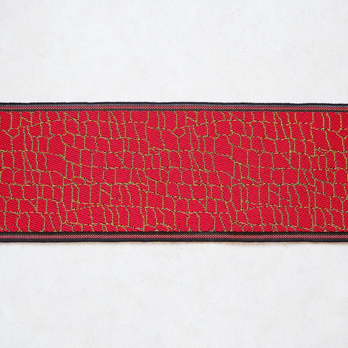 A close-up view of a red and black striped fabric with a textured pattern.