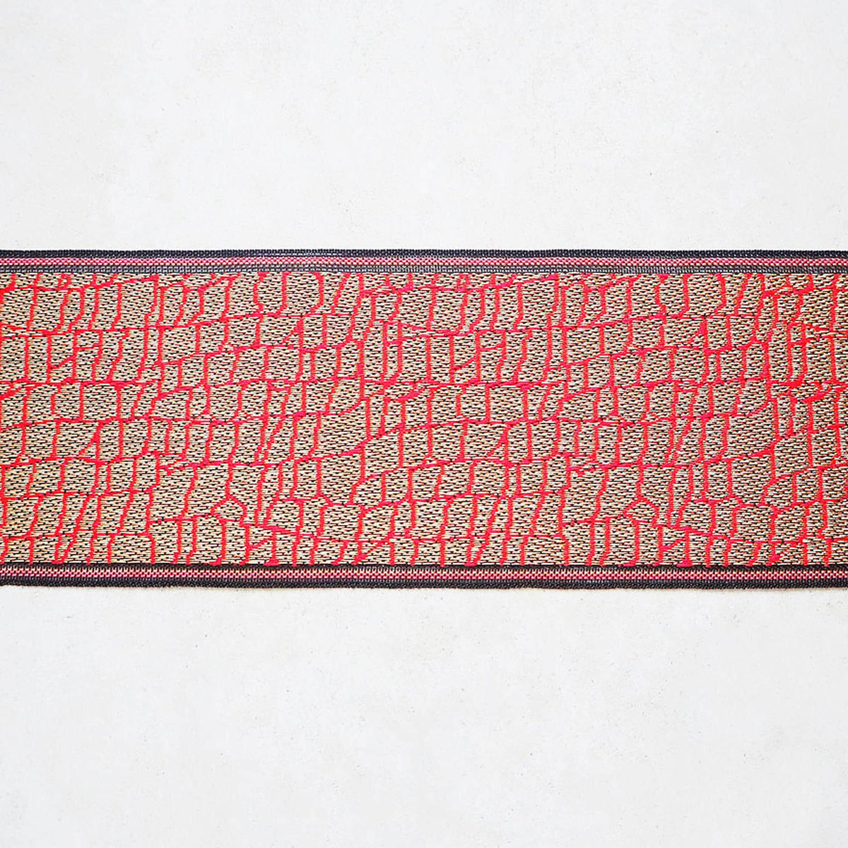 a red and black patterned fabric with a repeating geometric design.