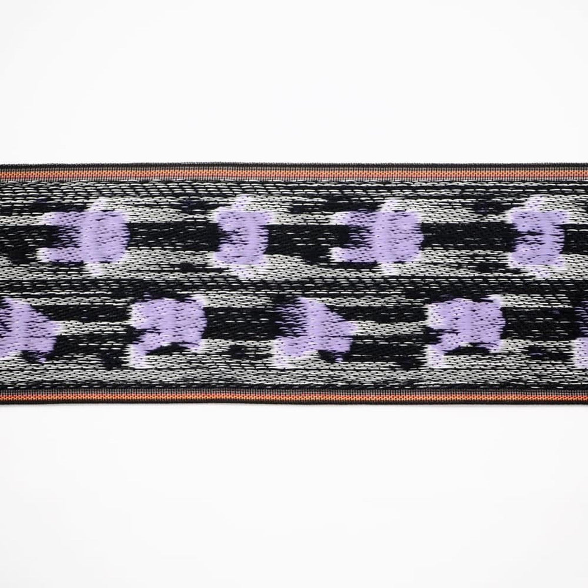 a close-up view of a patterned fabric with a repeating design of purple and black stripes.