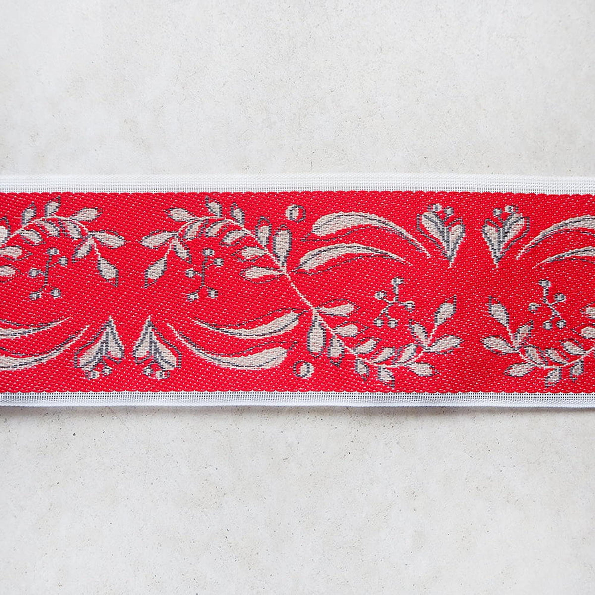 a red and white floral pattern on a white background.