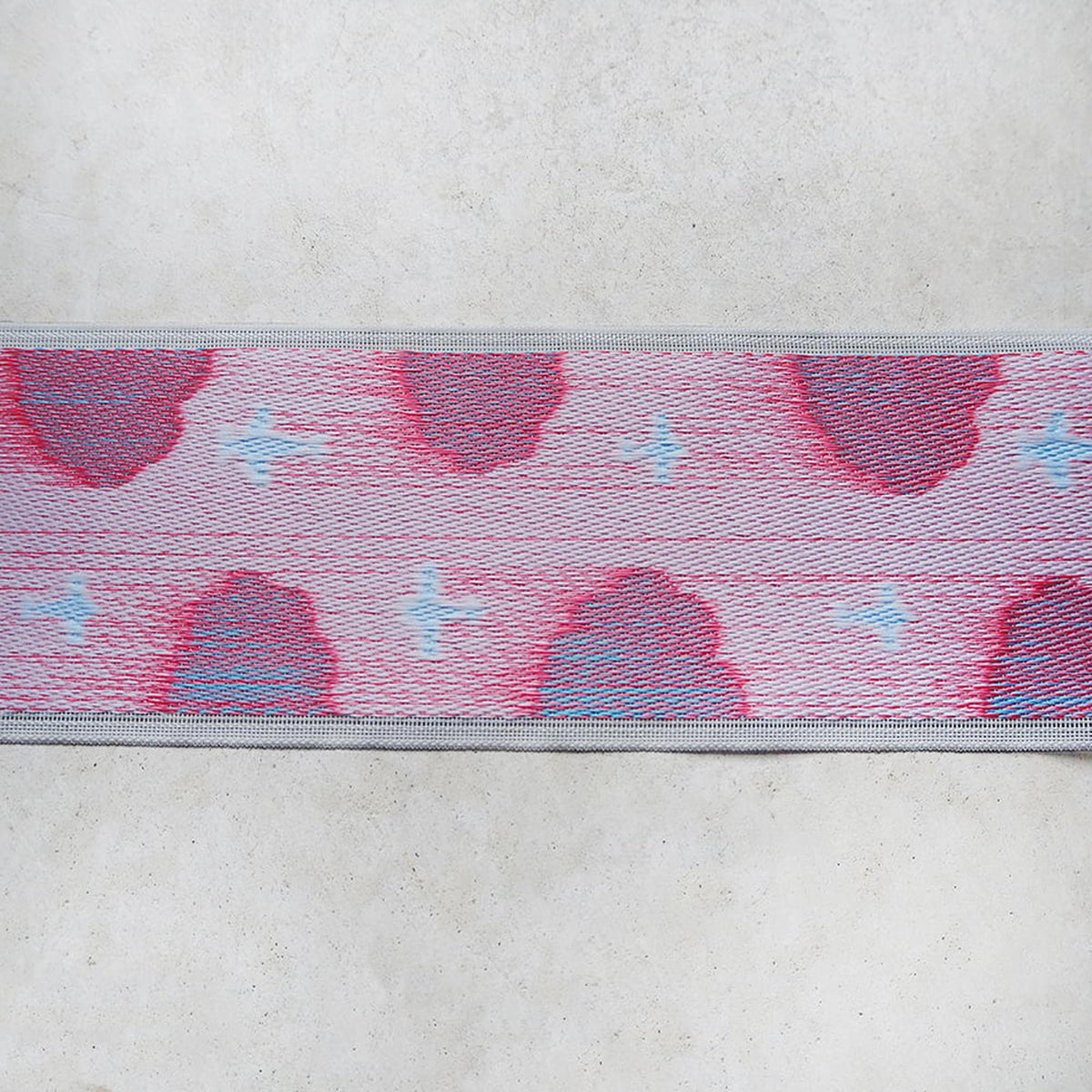 a close-up view of a fabric with a repeating pattern of red and blue hearts, creating a visually striking and colorful design.