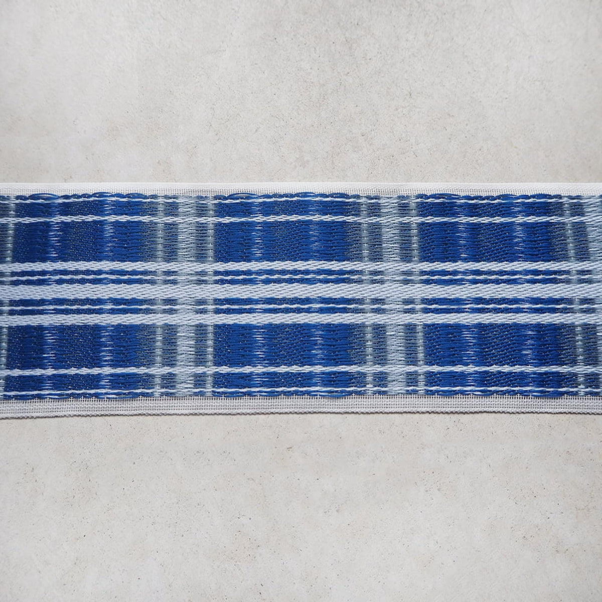 a close-up view of a blue and white plaid fabric, which appears to be a decorative textile or textile product.