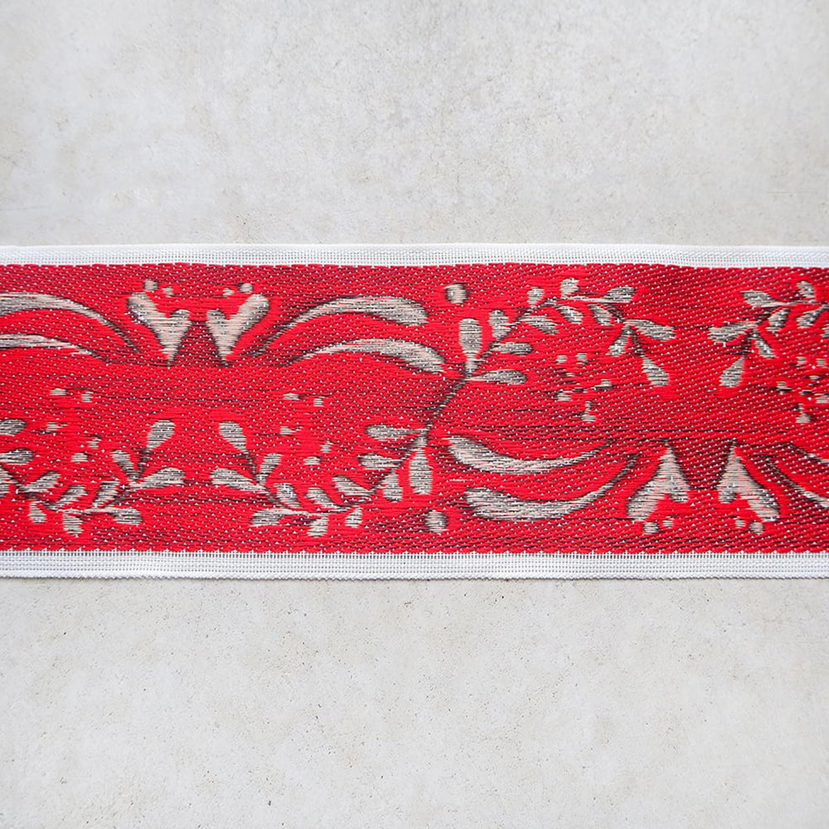 a red and white patterned fabric with a repeating floral design.