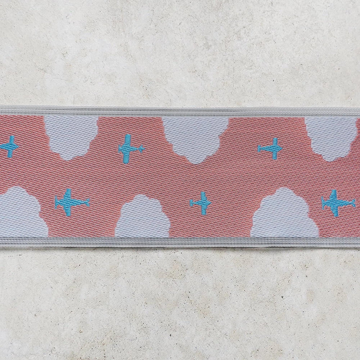 a pattern of clouds and airplanes on a fabric or textile.