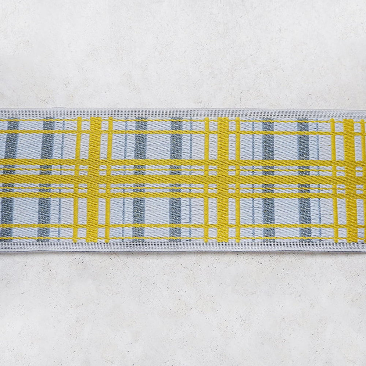 A close-up view of a yellow and gray plaid pattern on a white background.