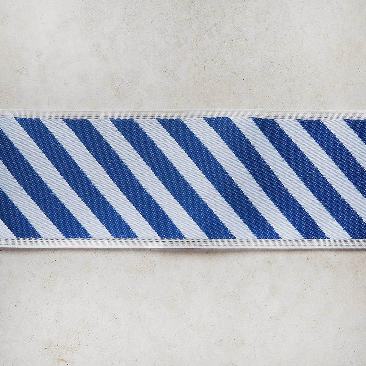 A close-up view of a blue and white striped ribbon or band, with the stripes arranged in a diagonal pattern.