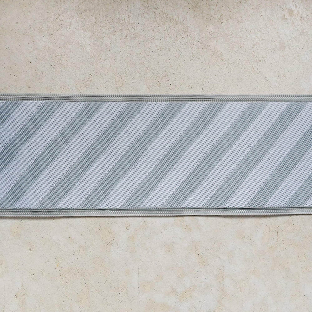 a close-up view of a fabric with diagonal stripes in shades of gray and white.