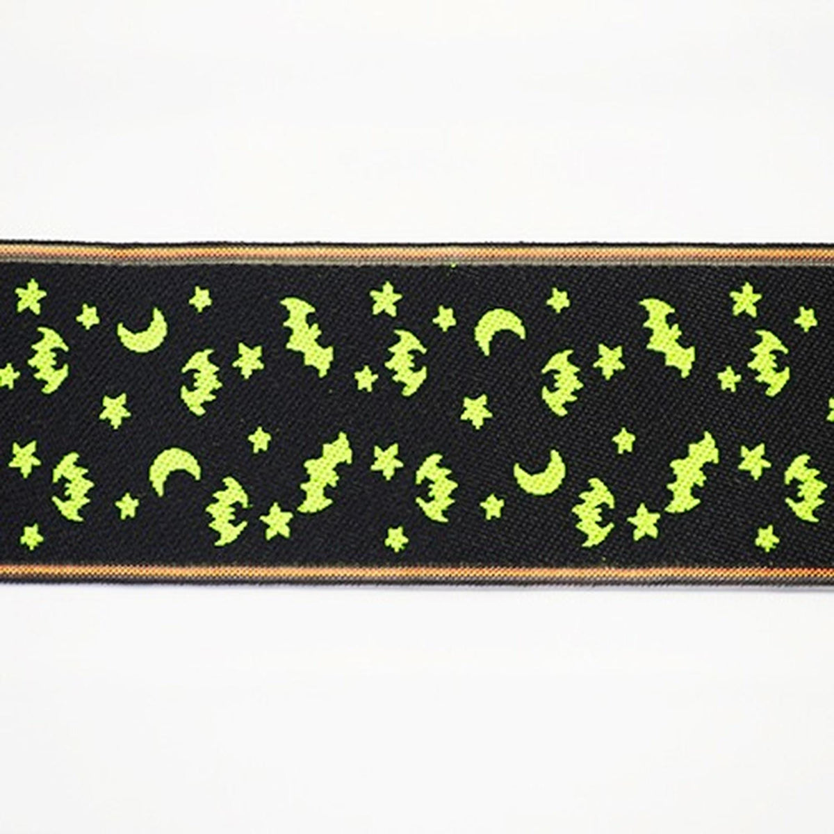 a black fabric with a repeating pattern of green bat and star shapes, creating a spooky and festive design.