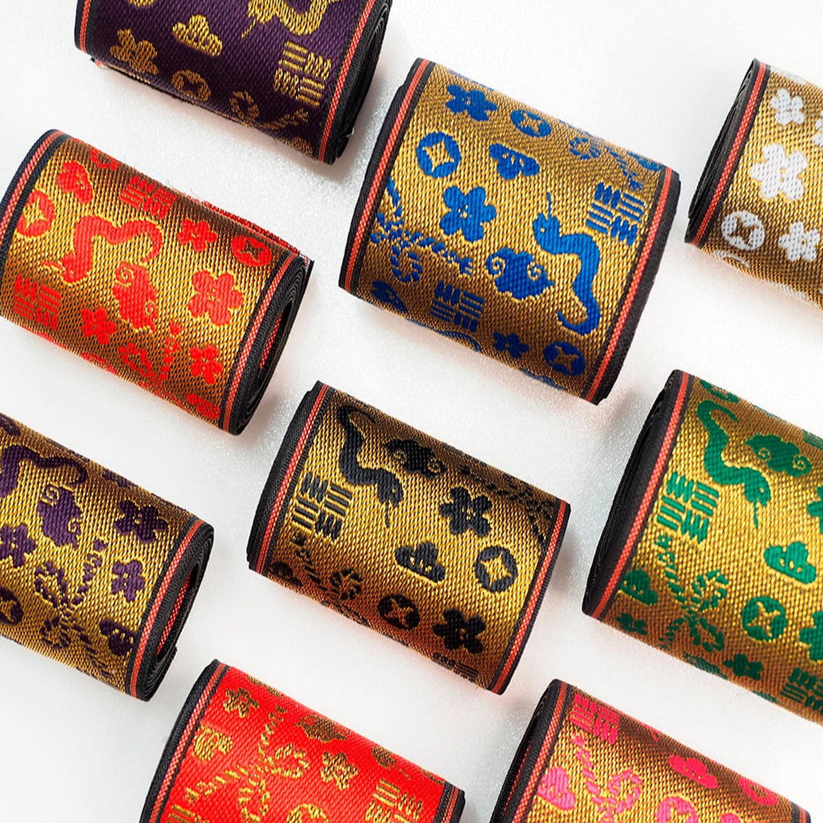 a collection of colorful, patterned fabric rolls or bags arranged in a grid-like pattern on a white background.