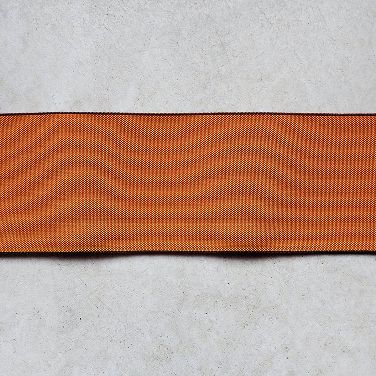a single, horizontal orange fabric strip against a plain white background.