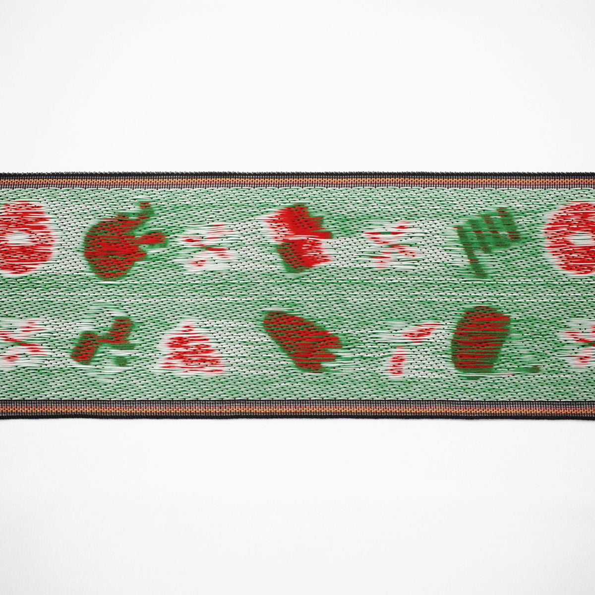 The image is a close-up of a green and red woven fabric with a repeating pattern of red and green shapes.