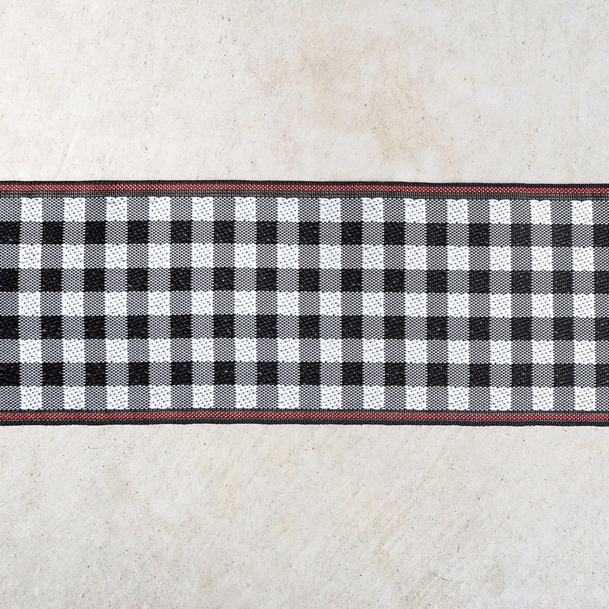 a close-up view of a black and white checkered pattern on a beige background.