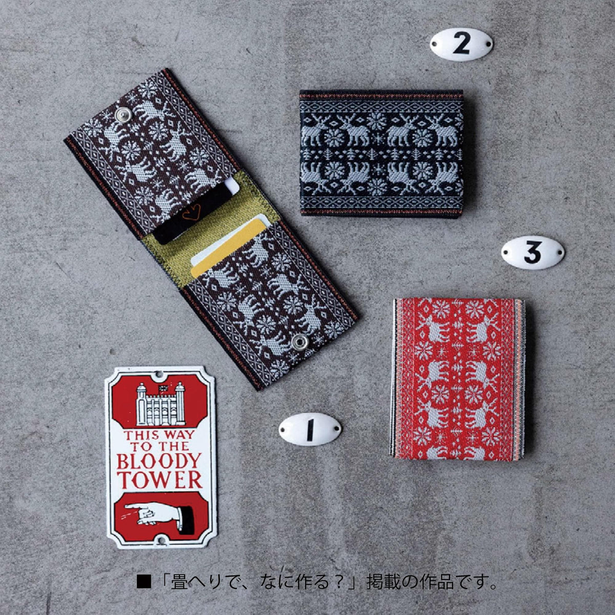 various items, including a wallet, a card holder, and a sign, all placed on a gray surface.