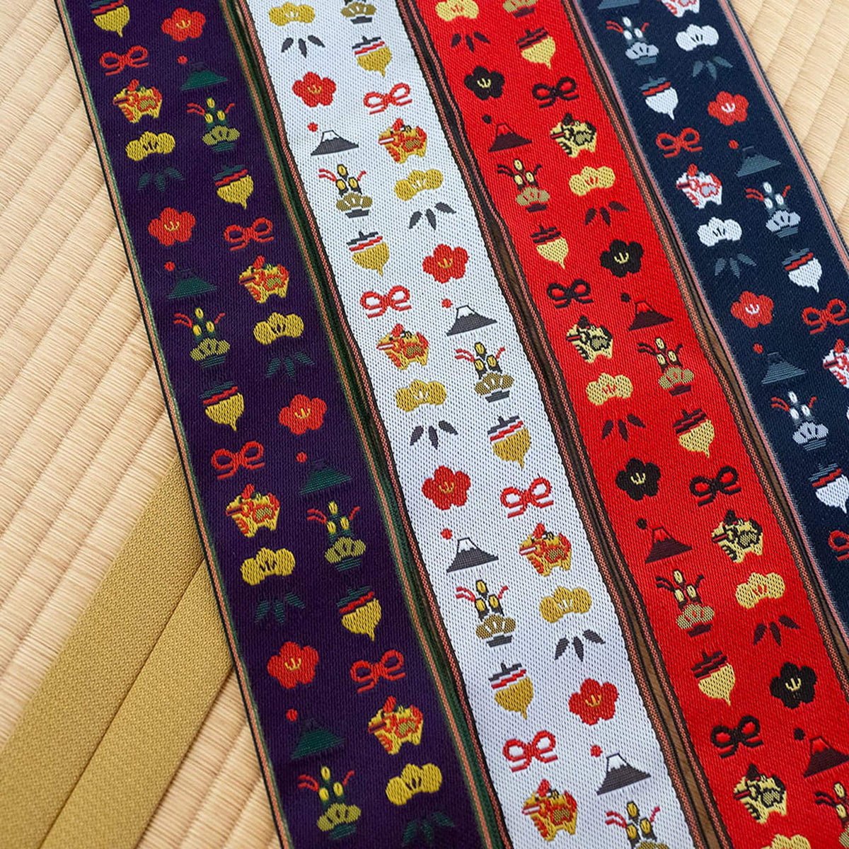 four colorful fabric strips with various patterns and designs, including flowers, mountains, and other decorative elements.