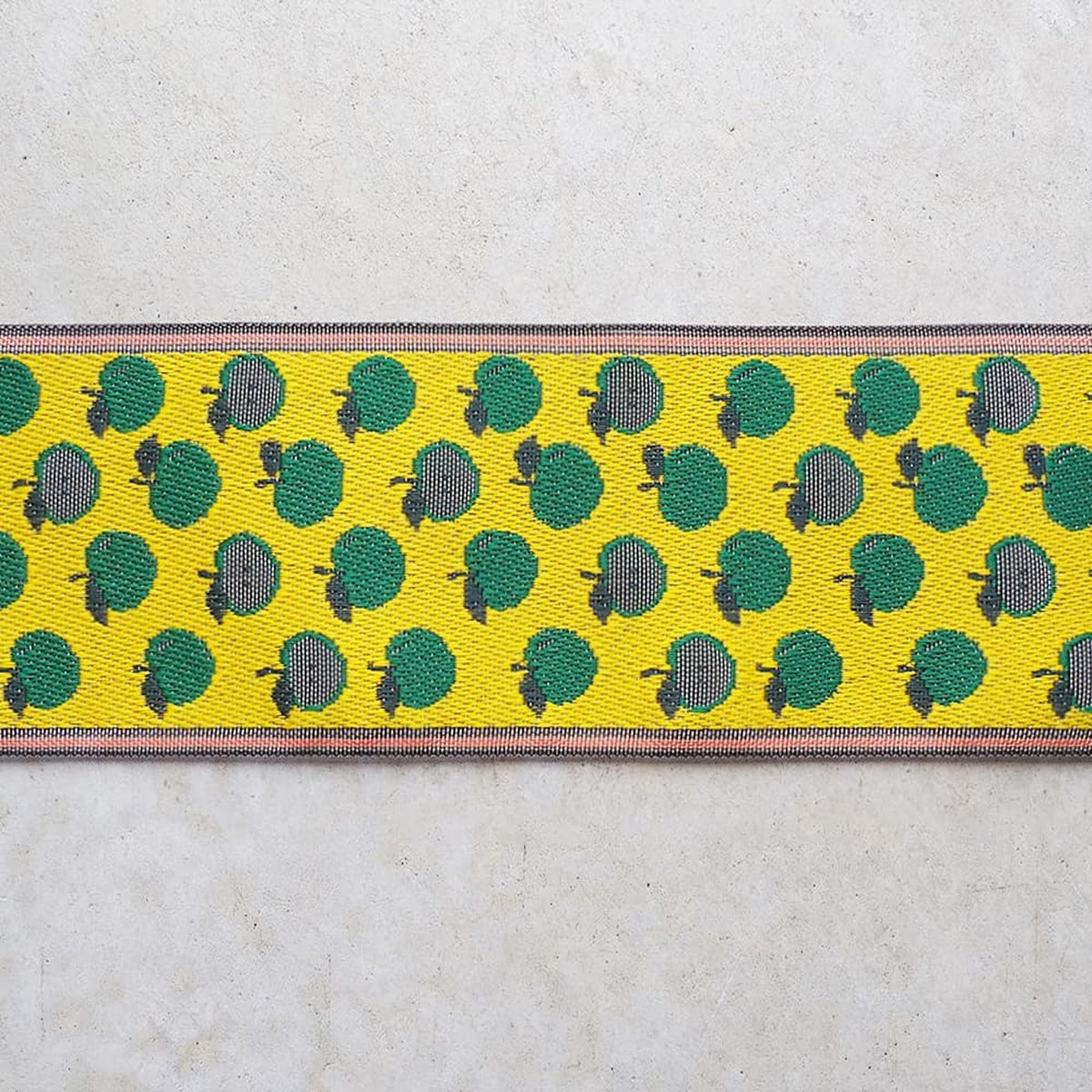 a repeating pattern of green apples on a yellow background, creating a vibrant and eye-catching design.