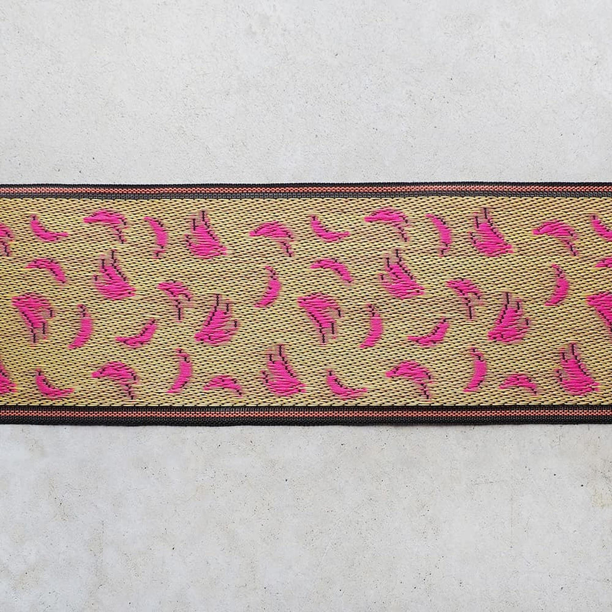 a decorative border with a repeating pattern of pink flowers on a beige background.