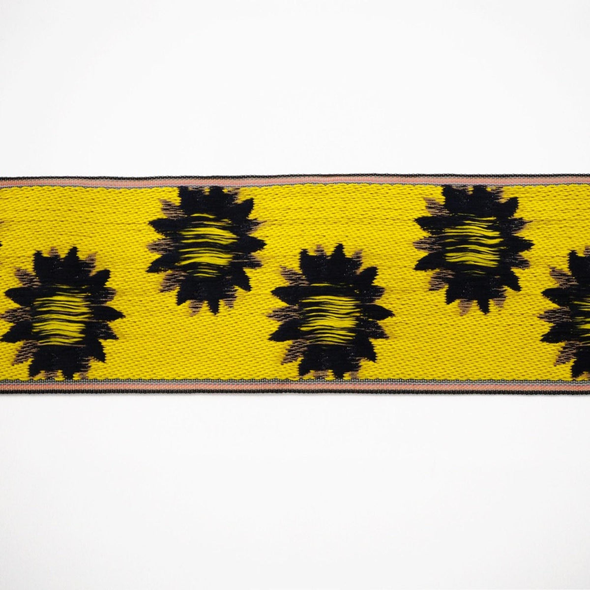 a close-up view of a yellow fabric with black floral patterns.