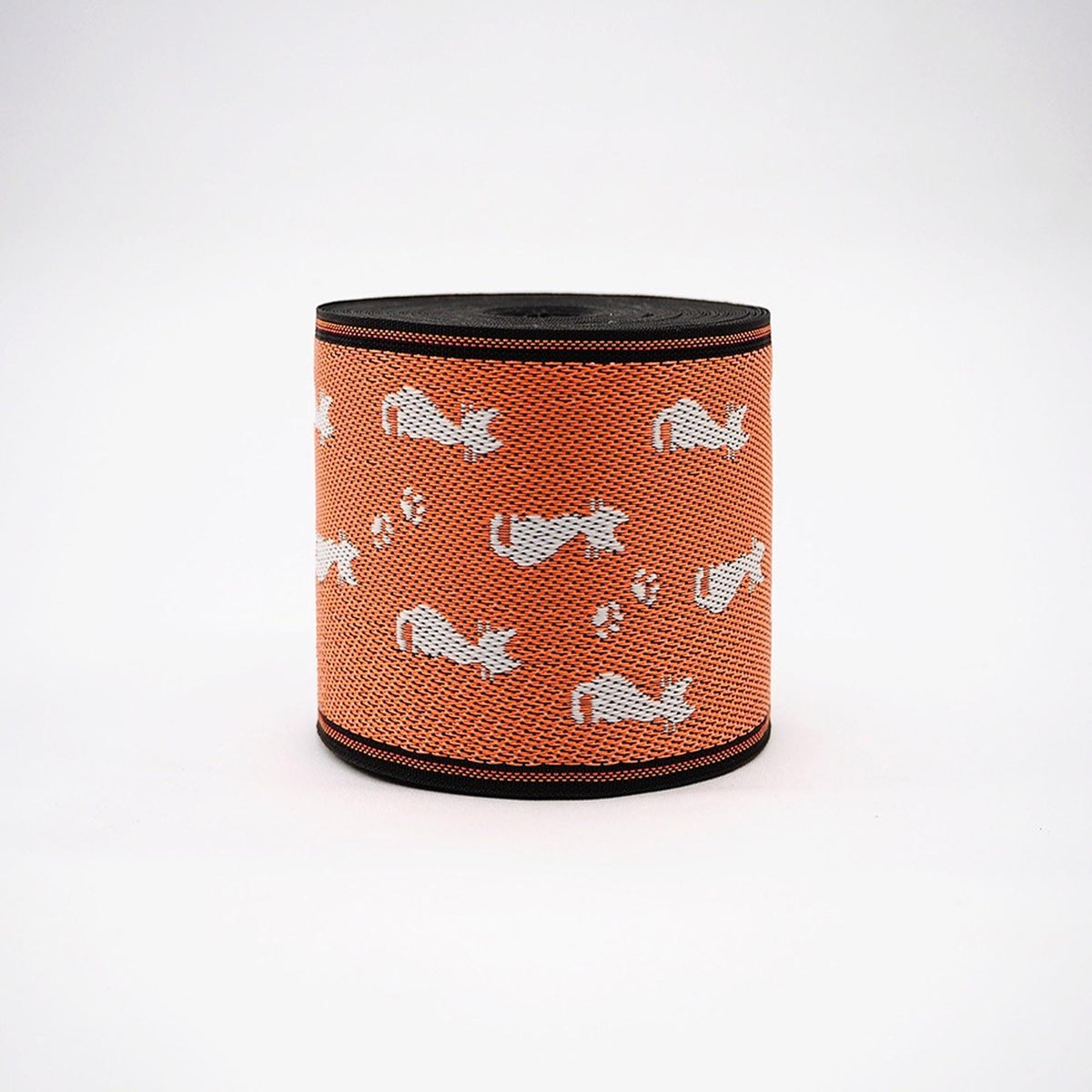 a cylindrical object with a pattern of white cats on an orange background.