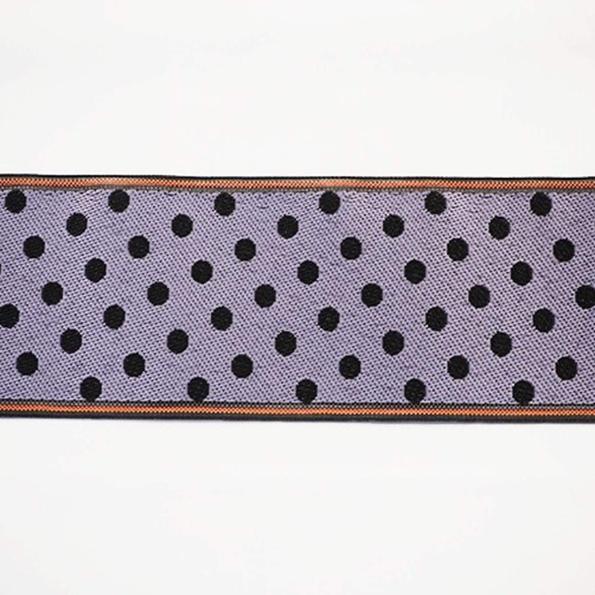 A close-up view of a fabric with a repeating pattern of black dots on a purple background, with a thin black border.