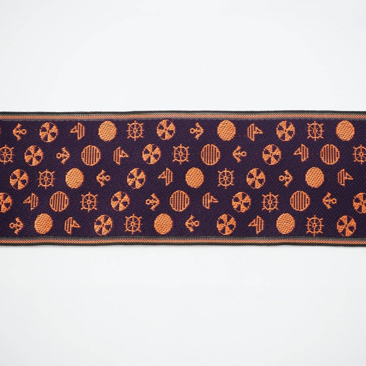 a repeating pattern of orange circles and orange ships on a dark purple background.