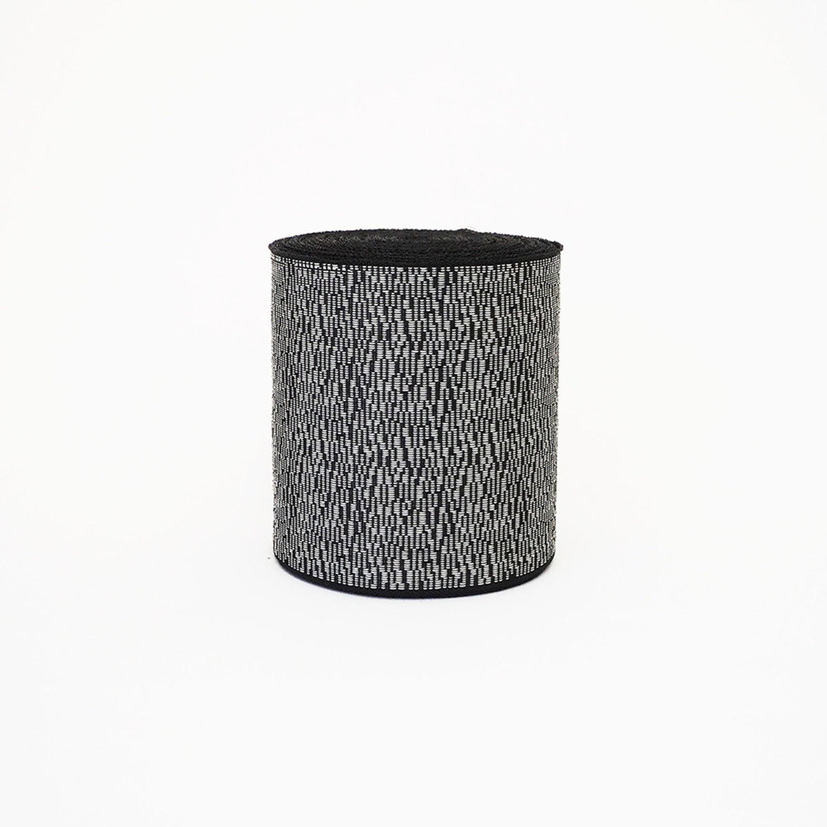 A cylindrical object with a black and white striped pattern, sitting against a white background.