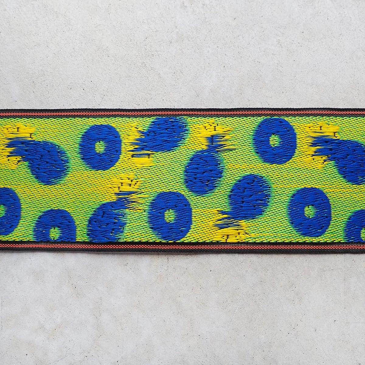 a vibrant, colorful pattern with blue and yellow circles and swirls on a white background.