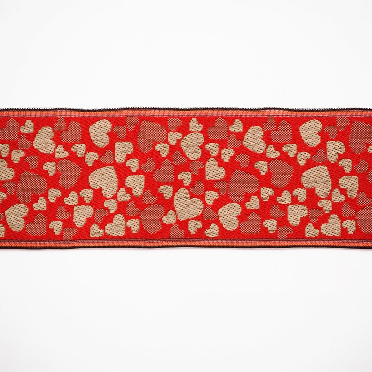 a red fabric with a repeating pattern of heart shapes in various shades of red and gold.