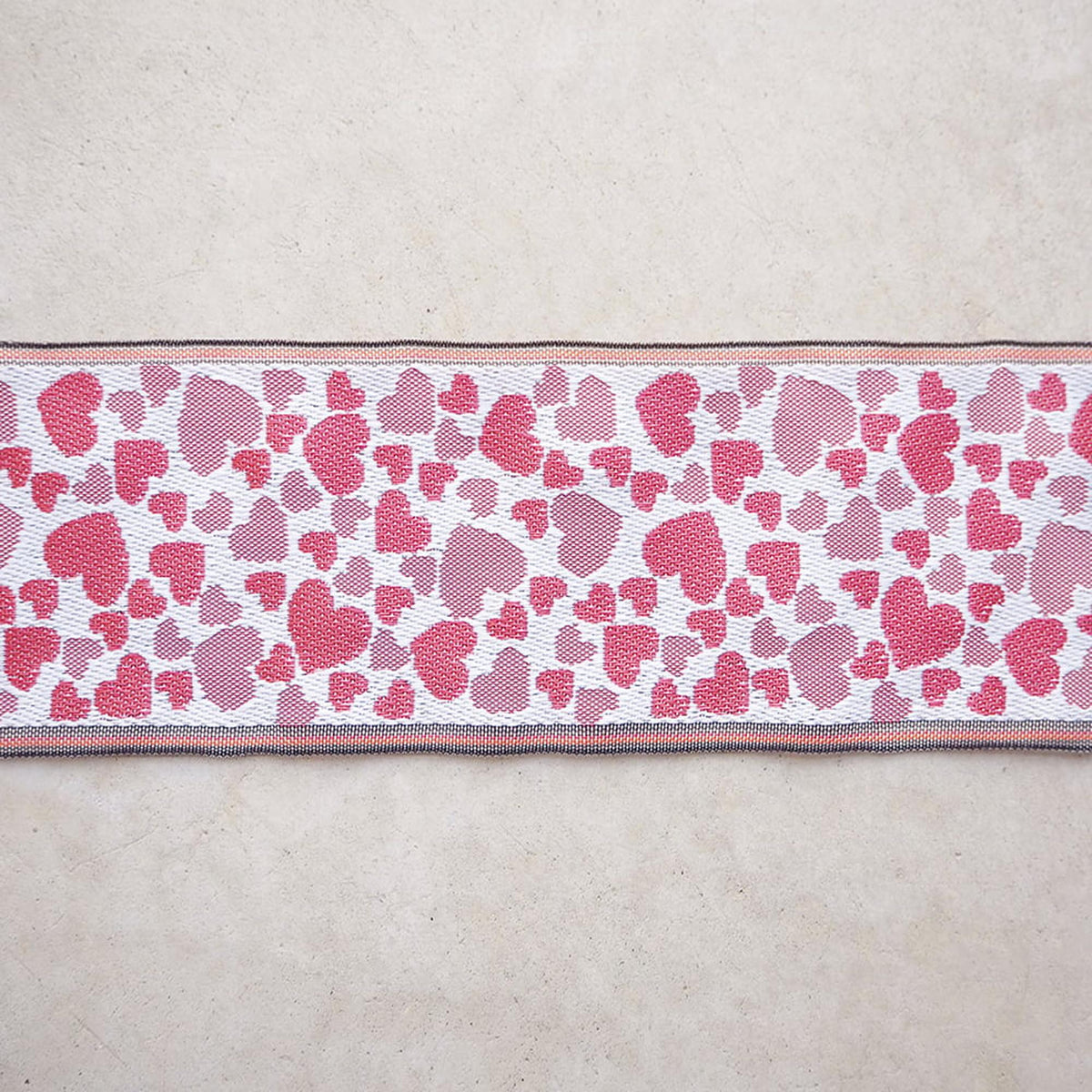 a long, narrow ribbon with a heart pattern on it, placed on a plain surface.