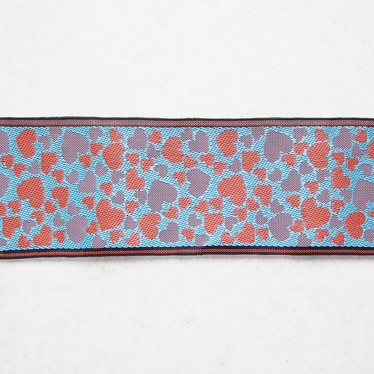 a close-up view of a colorful fabric with a pattern of red and blue hearts on a white background.
