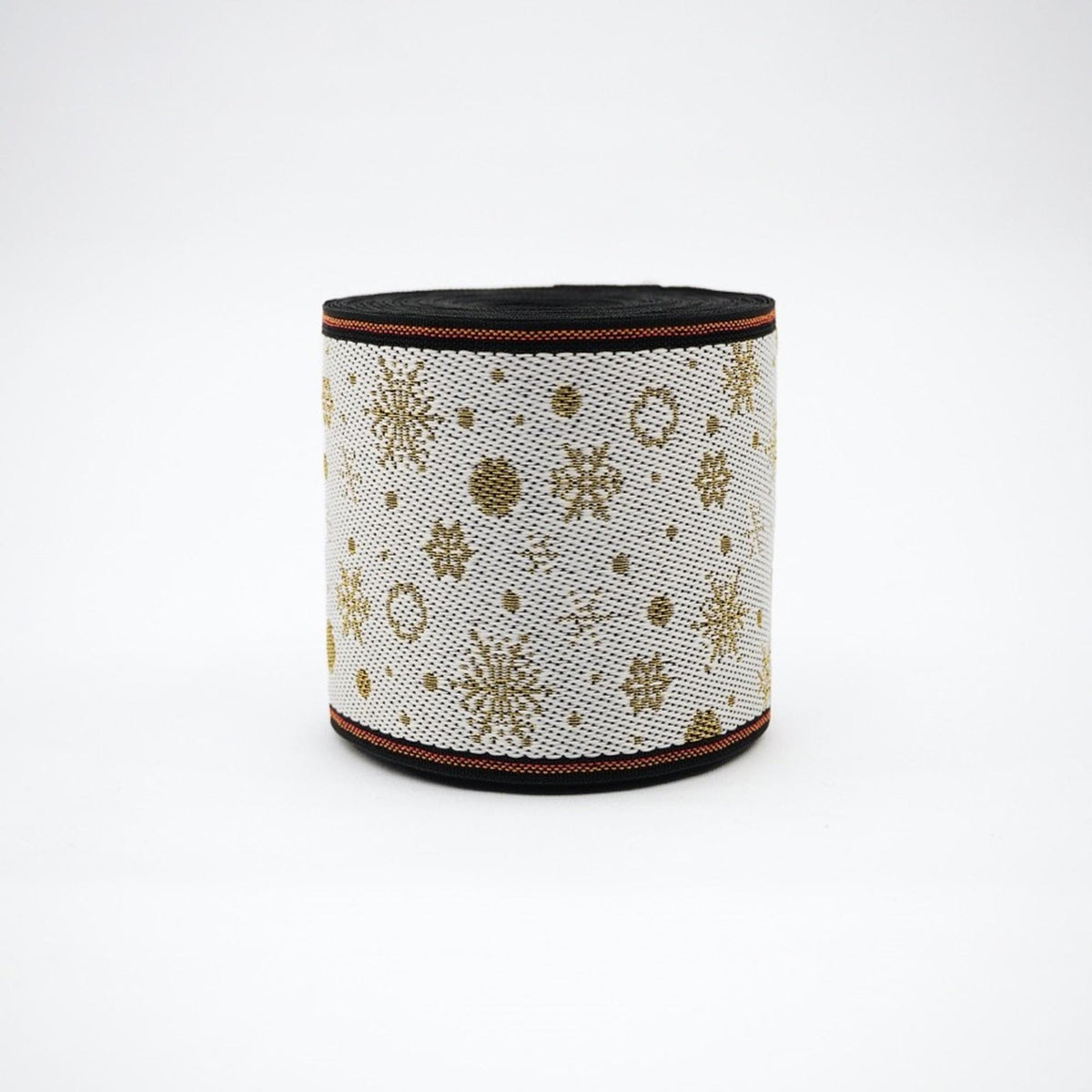 A white and gold snowflake-patterned fabric or material, possibly a decorative piece or accessory, with a black border or trim.