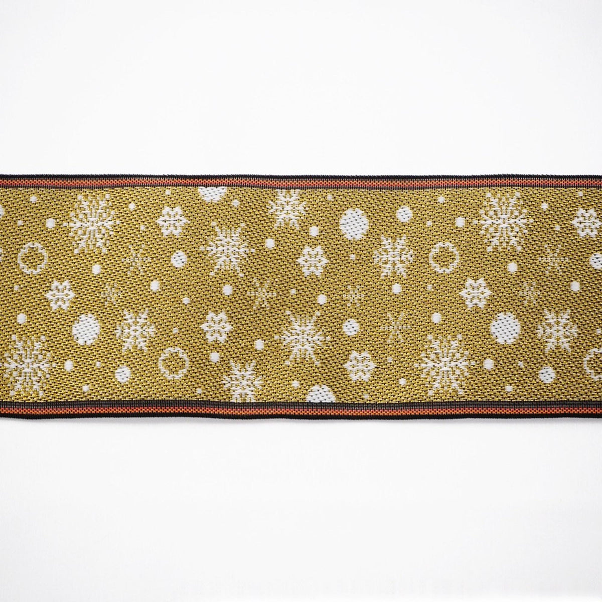 A decorative fabric with a repeating pattern of snowflakes and dots in shades of gold and white.