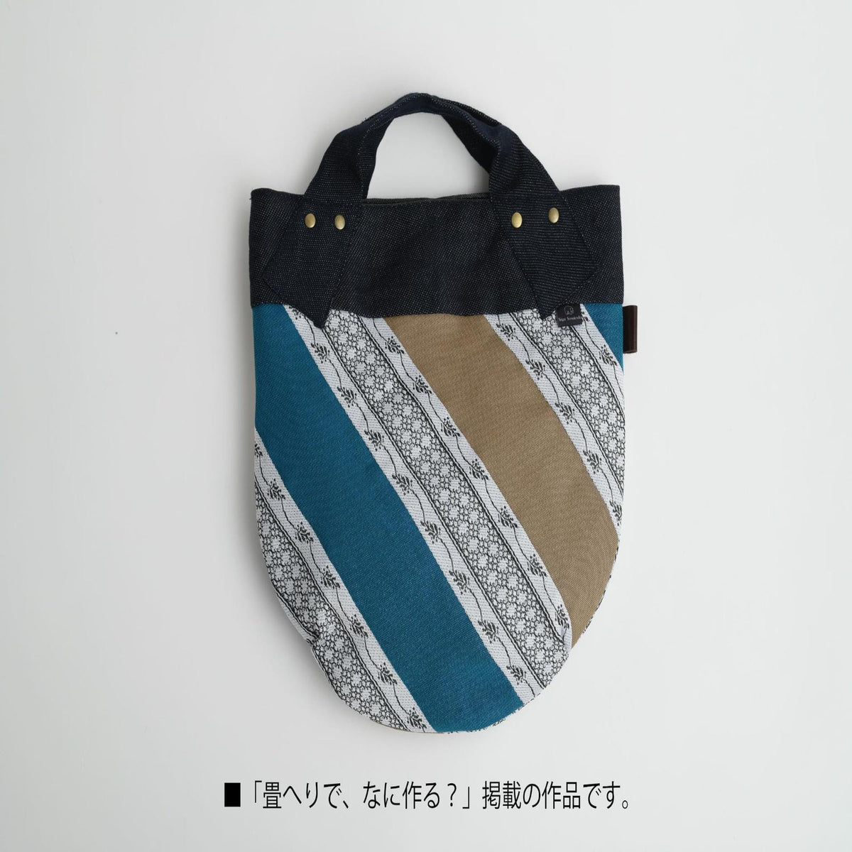 A colorful handbag with a striped pattern in shades of blue, white, and brown.