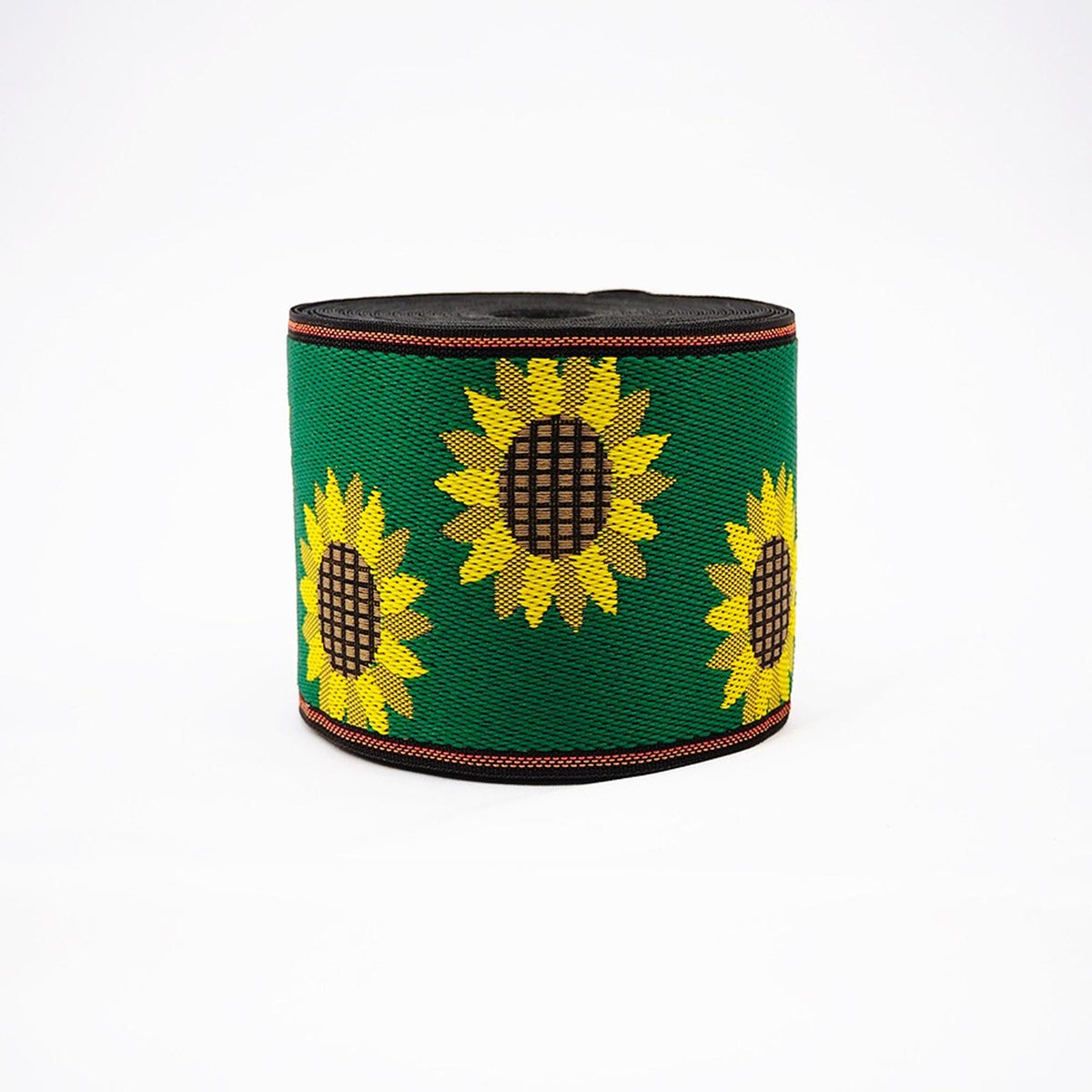 A green and black spool of ribbon with a repeating pattern of yellow sunflowers on it.