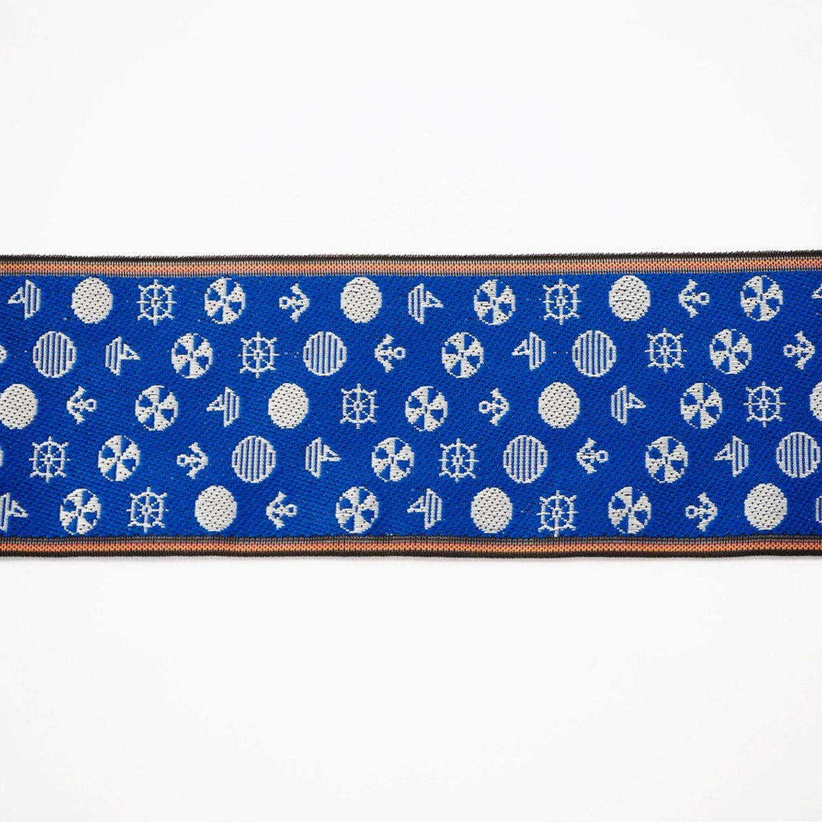 a blue fabric with a repeating pattern of white circles and symbols, such as ships, anchors, and sails, creating a nautical or maritime theme.