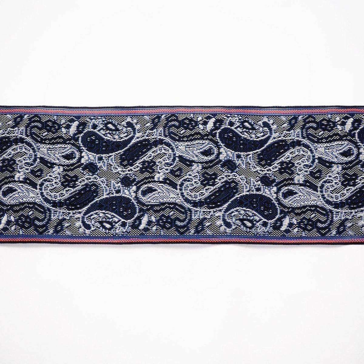 a close-up view of a decorative fabric with a repeating paisley pattern in shades of blue and white.