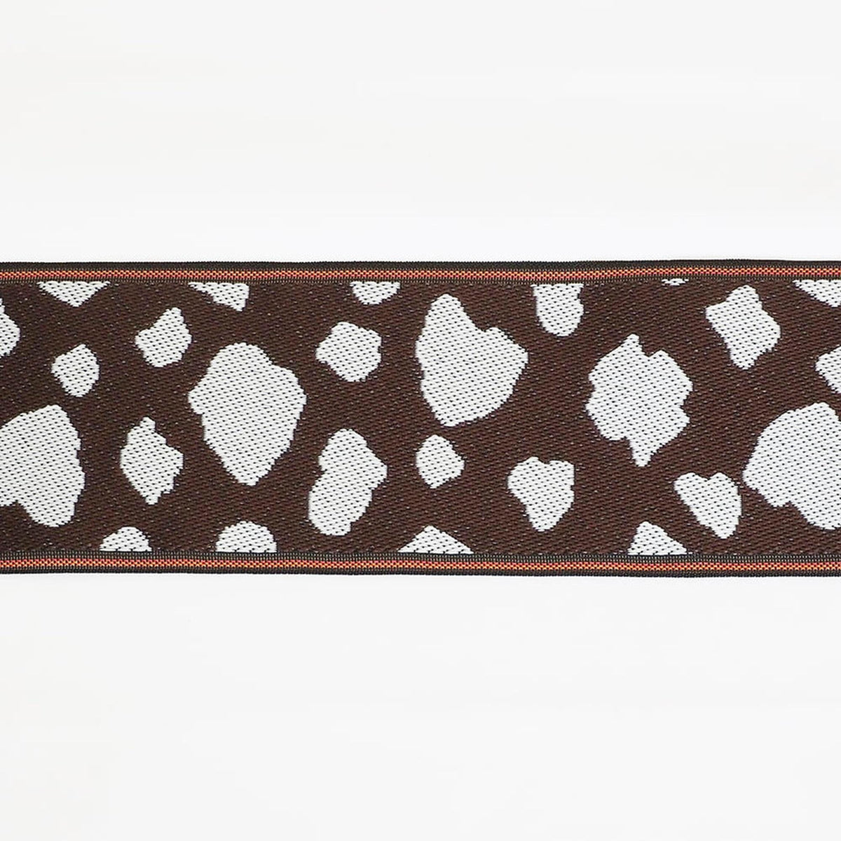 a close-up view of a brown and white patterned fabric, with a brown border around it.