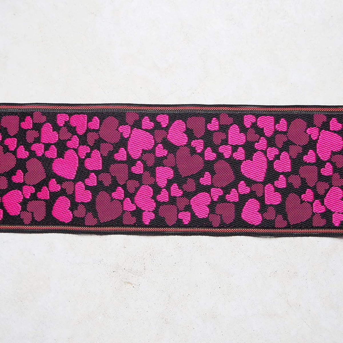 a black and pink heart-patterned fabric with a black border.
