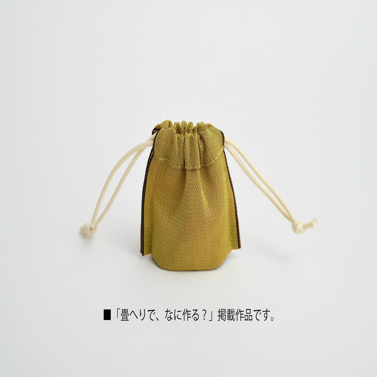 A small yellow mesh bag with a drawstring closure and two white handles, sitting on a plain white background.
